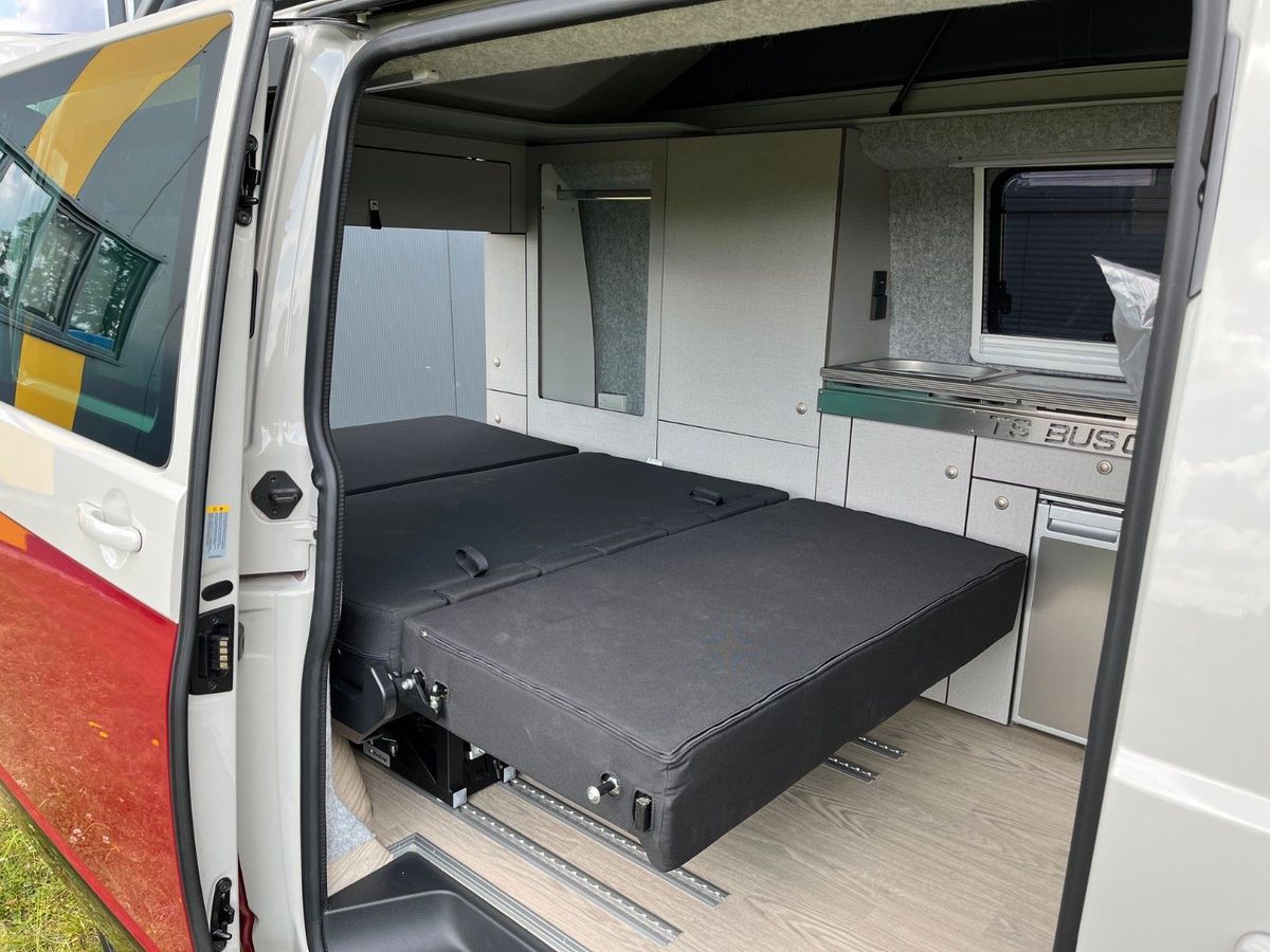VW T6.1 in Weinrot/Ascotgrau, Sitzbank zur Liegefläche umgebaut