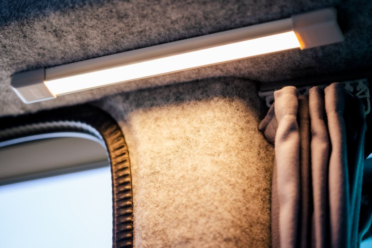 Warmes LED-Licht über gedämmter Filzverkleidung und Vorhang im Innenraum